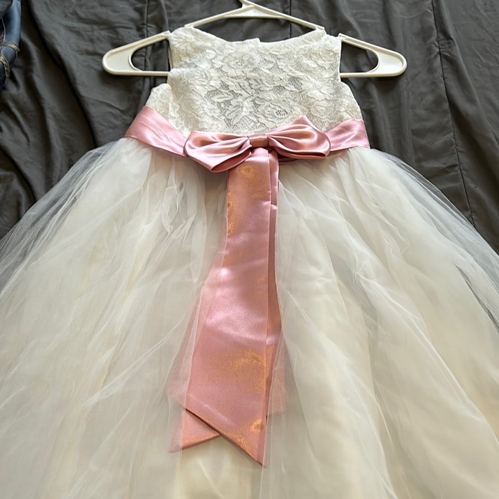 It’s a white flower girl dress with a blush pink bow